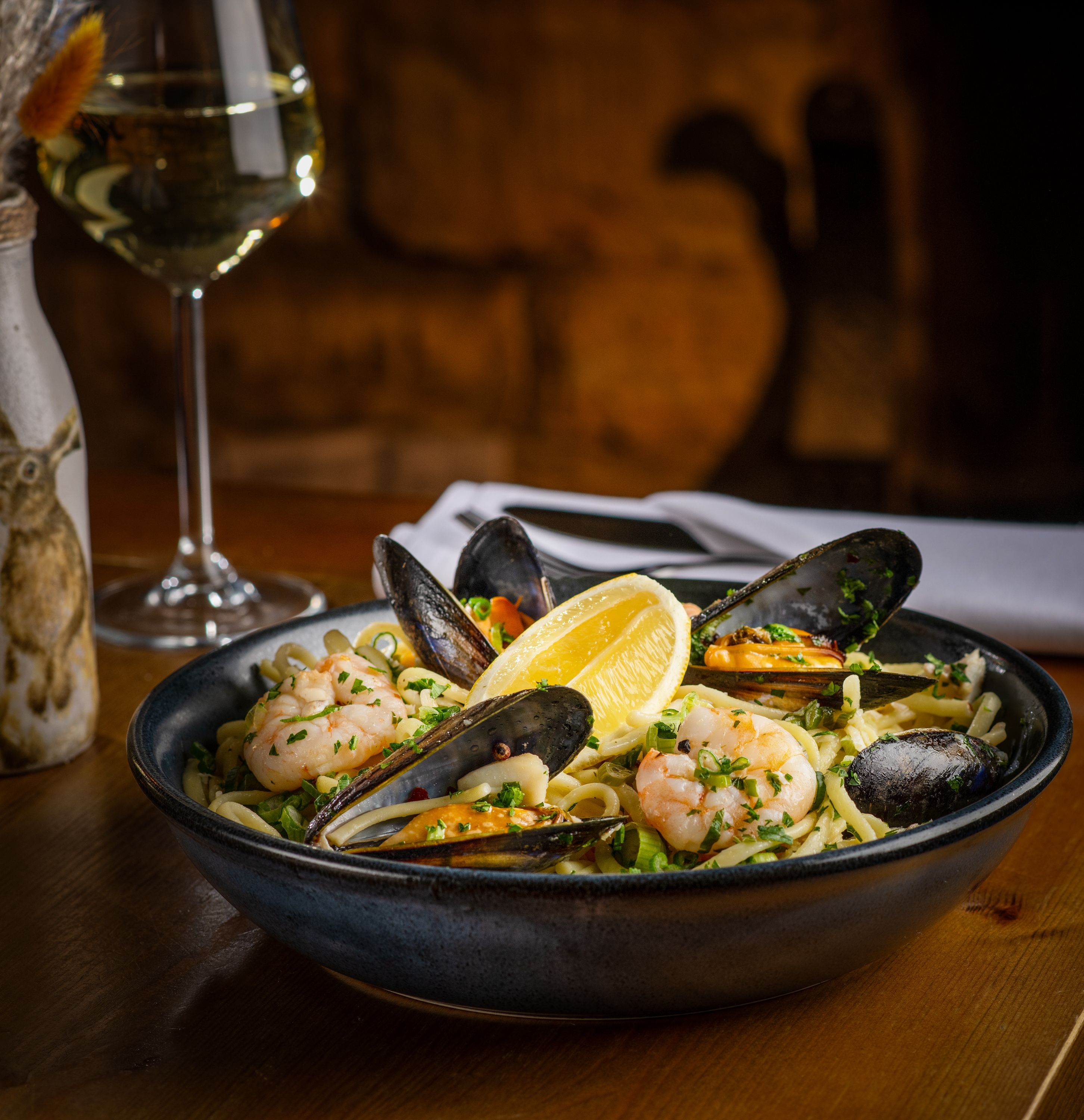 a plate of food with white wine on a table