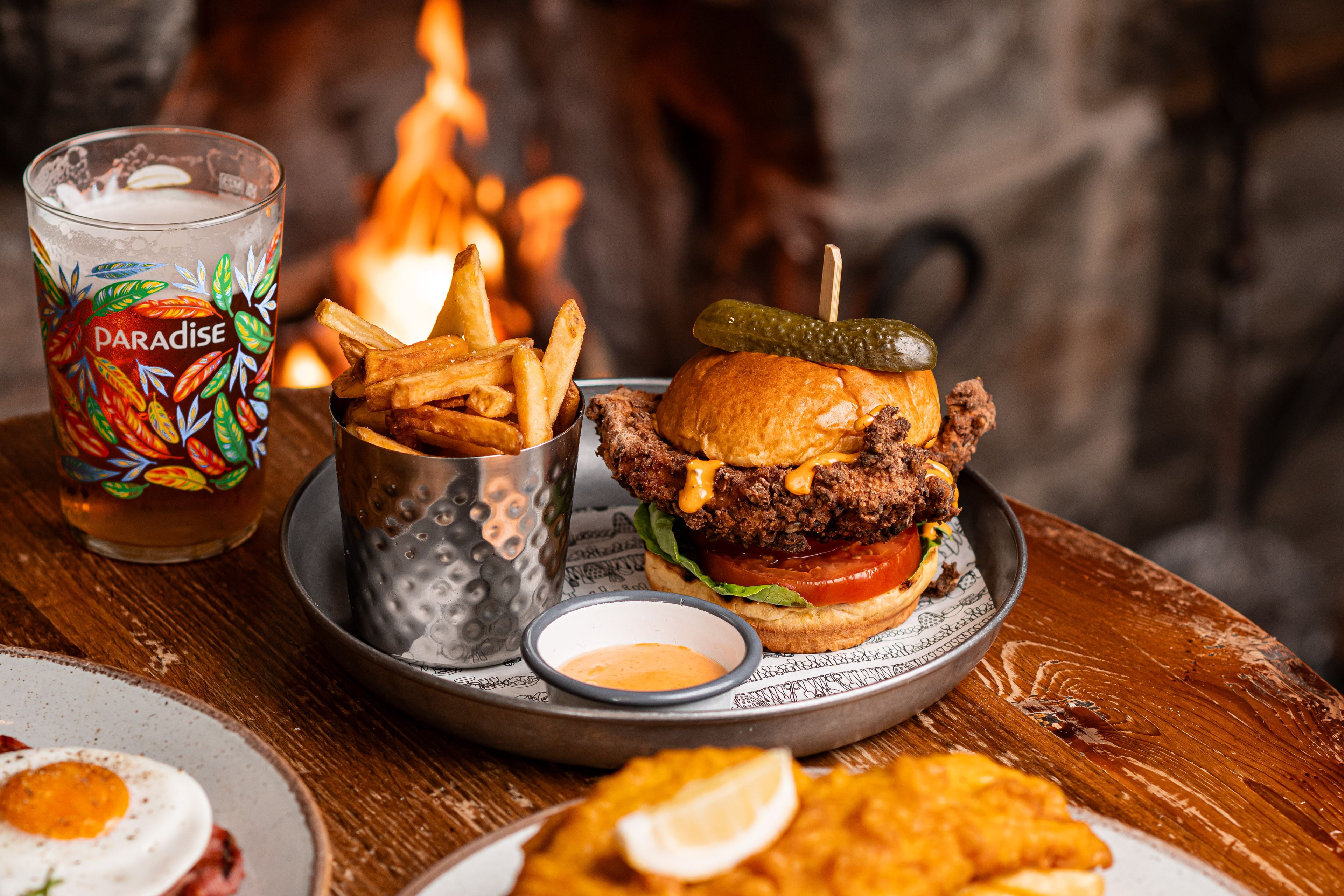 chicken burger with a pint of thwaites ale by the fire